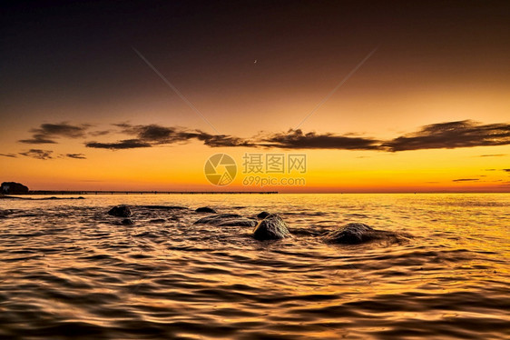 夕阳西下海边的礁石图片