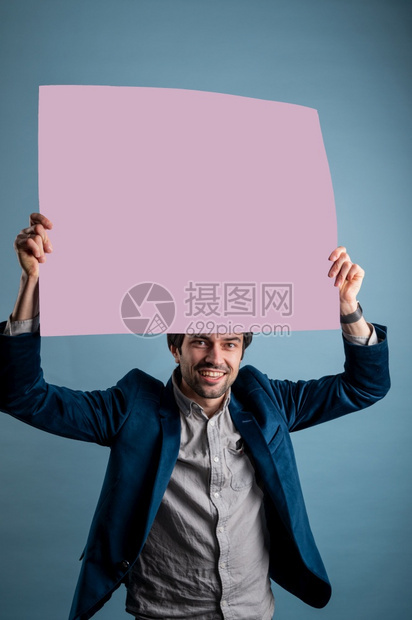 男快乐的人拿着粉红色的海报快乐微笑年轻人展示空白招牌与的复制间区域用于标语或广告短信概念中的白种人男模海报快乐标语牌图片