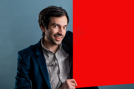男快乐的人拿着红色海报快乐微笑的年轻人展示空白招牌与的复制间区域用于标语或广告短信概念中的白人男模特种随意的图片