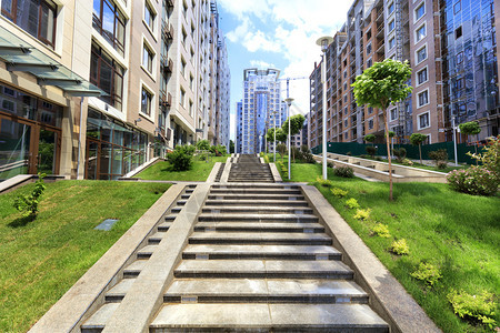 水平的这条路从灰花岗岩在绿草中的石阶梯上爬楼并处于现代城市新住宅区的背景之下花岗岩楼梯的台阶向上攀升到城市街道的斜坡灰色城市图片