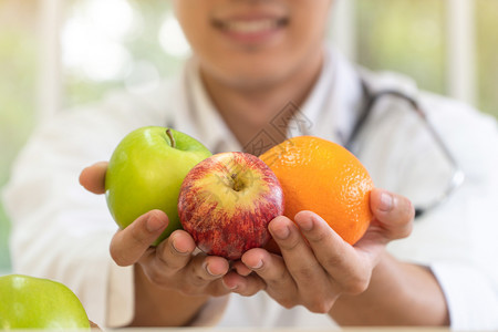 医生或营养学家持有新鲜果子橙红苹和绿在诊所微笑健康饮食营养品概念作为良好健康的处方水果是药品营养食概念维他命卫生保健或者背景图片