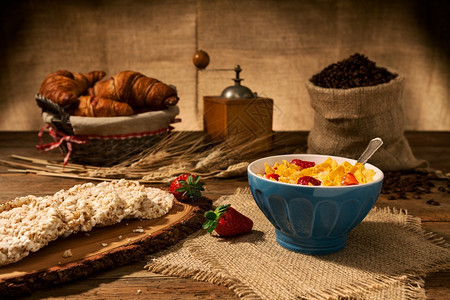 木制的蓝色头欧陆式早餐包括玉米片和草莓一杯牛奶和米果放在一张旧木桌上欧式早餐玉米片和草莓图片