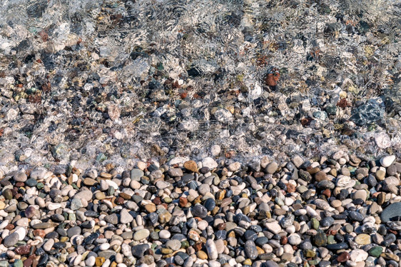 海边小色湿卵石从Texture壁纸背景上的近距离视图海洋丰富多彩的鹅卵石图片