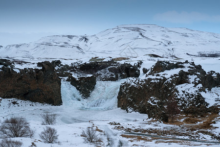 冰冻的Hjalparfos瀑布在欧洲冰岛一个多云的清晨冬天荒野旅行全景图片