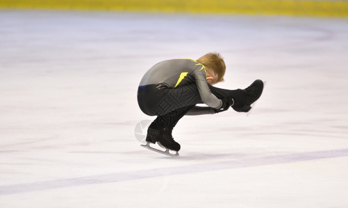 劳斯莱锻炼男孩式滑冰在带人工的滑场上鞋图片