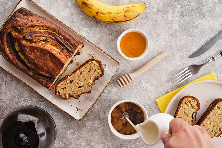 蜜糖切片香蕉面包新鲜烘烤自制香蕉派上面有蜂蜜和黄油背景浅灰色甜的图片