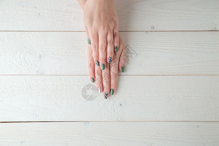 化妆品在浅木背景上用美丽的修指甲握着女手化福利图片