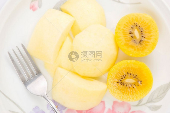 开胃菜生的金果和苹切片盘子里有叉热带图片