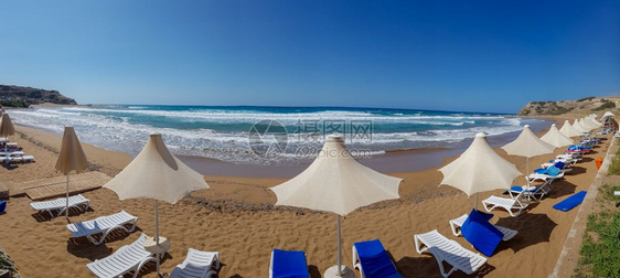 户外椅子塞浦路斯岛Davlos海滩的雨伞和防晒层全景帕利卡拉斯图片