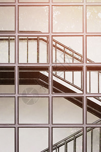 奢华内部的玻璃墙表面阳光在现代建筑内垂直架有黑色金属阶梯的玻璃墙面泰国图片