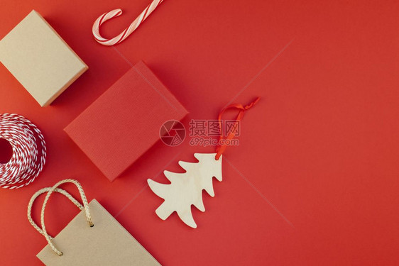新年或圣诞礼物由丝带平板包着的彩礼裹在顶端最高视景2019年Xmas节2019年庆日祝手工制作的礼品盒红纸背景上圣诞节购物高架图片