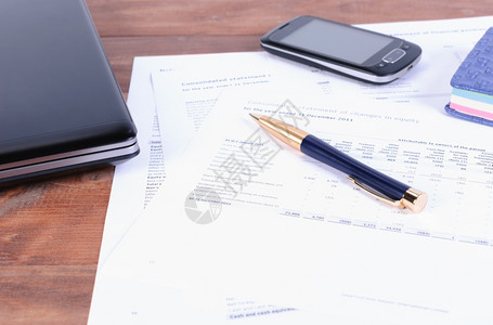 图表文档商务附件一支笔部电话和手提脑桌上有财务文件笔移动电话放在税务和财文件中办公室图片