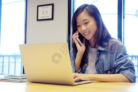 互联网年轻亚洲女使用智能手机和笔记本电脑微笑快乐和放松情绪在床上房间背景电话上的人在家工作生活方式中曼谷商业图片