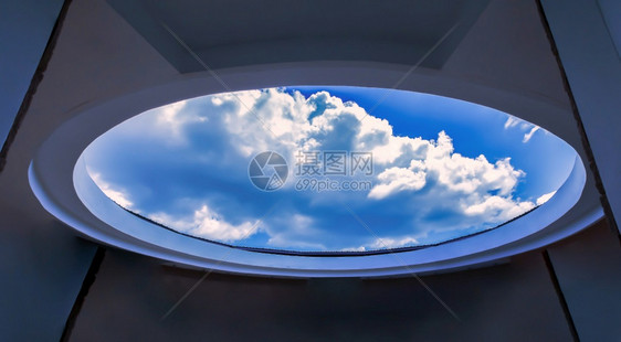 蓝色的圆形混凝土结构从自下到白云和蓝天空的视角现代内地以云为焦点墙圆顶图片