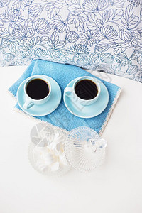 食物蓝色餐巾纸上的两个蓝色咖啡杯和棉花糖的碟子蓝色餐巾纸上的两个蓝色咖啡杯和棉花糖的碟子陶器美食图片