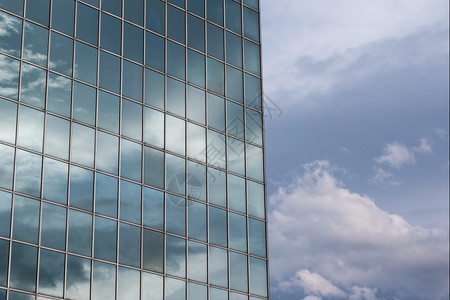现代的建筑学在玻璃大楼中反射的蓝天和云颜色图片