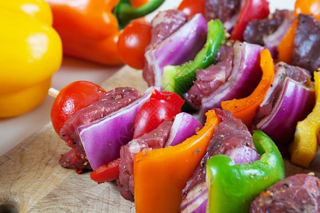 三个新鲜准备的牛肉烤箱配有蔬菜加碘和备供烧烤浅地深处使用晚餐番茄紫色的图片