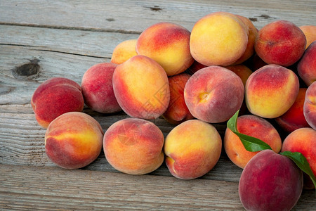 油桃多汁的夏天棕色木制背景的桃子皮花蜜果图片