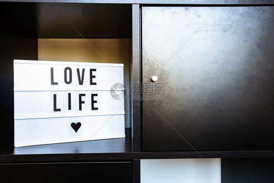 黑色柜子里一块写着LOVE的木板图片