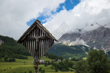 旅行木环十字和意大利DolomitesAlpps在夏季Wooden十字与意大利DolomitesAlmps在背景上爬坡道图片