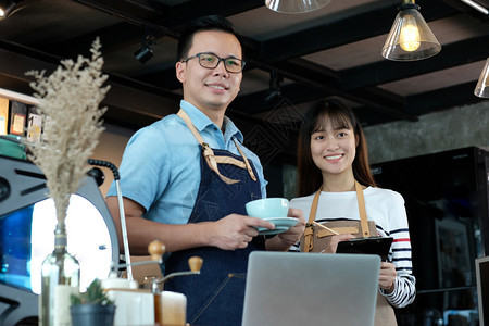 年轻的在咖啡馆柜台背景小商业主食品和饮料业面笑脸的咖啡杯中喝自助餐厅亚洲人图片