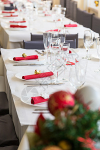 季节为了与红装饰nsapkins的圣诞晚宴餐桌燃烧图片