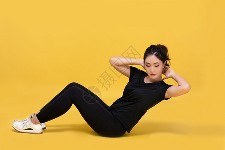 运动服深蹲苗条的快乐笑美丽肖像年轻的亚洲女在黄色背景上运动锻炼健身女孩有氧和健康的概念有氧和健康图片