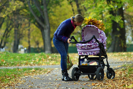 公园里的巡护员站在公园上面有黄色的秋叶常设学步儿童美丽图片