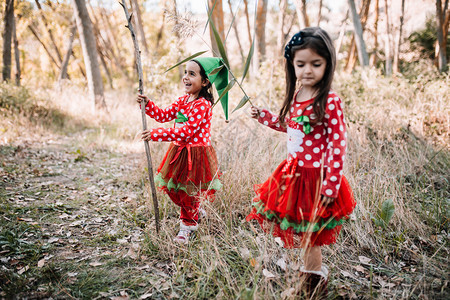 分支机构女孩在森林中伪装成圣诞节与树枝玩耍年轻的伪装图片