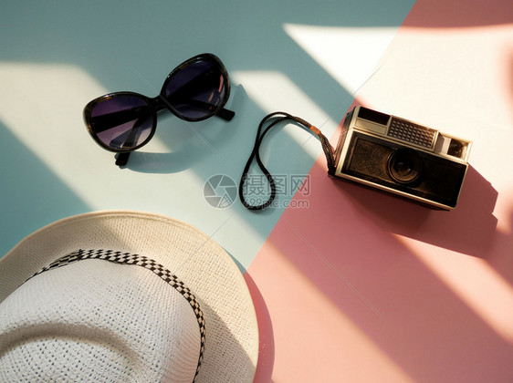 夏天复古的带照相机帽子和墨镜并贴彩色背景的旅游者平板配件用品假日概念小样图片