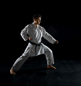 防御男空手道拳在战斗姿势中黑暗背景男子在空手道锻炼武术打斗比赛上男空手道拳在战斗姿势中一种运动图片