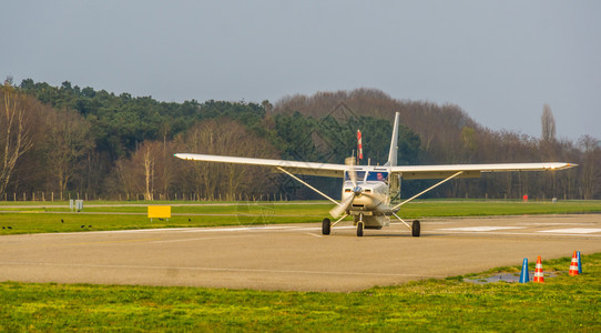 飞行休闲的复古白色飞机降落在空中地带娱乐体育和爱好空中运输等机场上图片