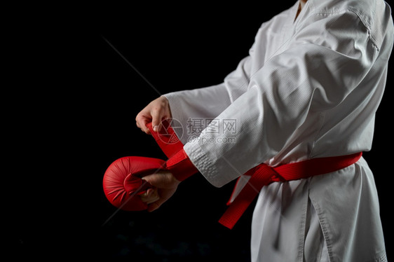 白和服的男空手道斗士有红带和手套战斗姿势黑暗背景的卡拉特运动武术拳击前训练有红带和手套的男空道斗士人争艺术图片