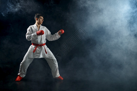 专业的白和服红手套的男空道斗士战姿势运动方面的黑暗背景拳手武术比赛前训练白和服的男空手道斗士和红套竞赛运动员图片