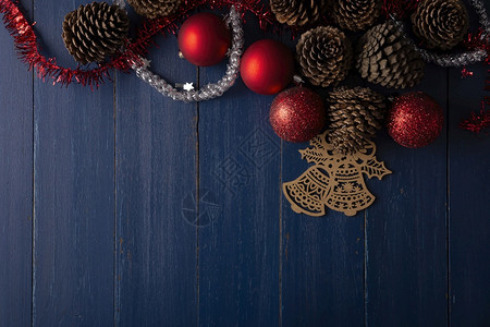 用于古年蓝木本底的圣诞装饰松果和红圣诞节球平面图象有文本复制版间距木板季节问候图片