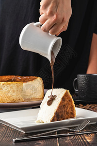 自制切碎的桑塞巴斯蒂安芝士蛋糕和木制桌上的咖啡烧焦美食图片