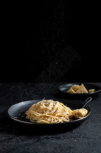 佩菜单CacioePepe意大利面配奶酪和胡椒在深色背景上的黑盘Cacio意大利面配奶酪和胡椒在黑色背景上的盘色图片