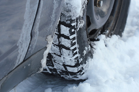 白色的冬季汽车轮胎在被雪覆盖的道路上特写镜头冬季汽车轮胎在被雪覆盖的道路上特写镜头冰冷驾驶图片