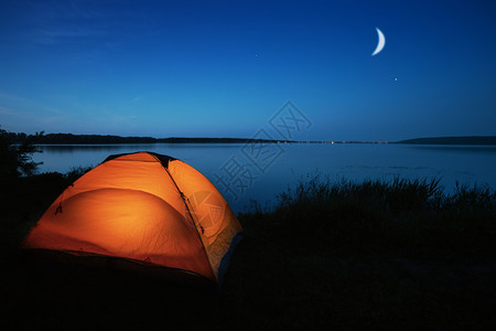 野营假期夜空点燃的橙色旅游帐篷图片