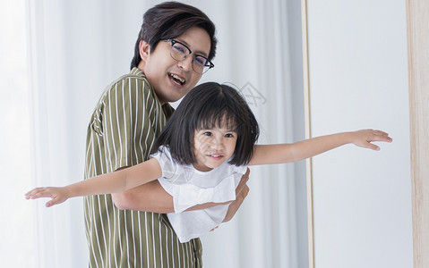 女关心亚裔父亲和女儿在节假日家一起玩耍童年图片