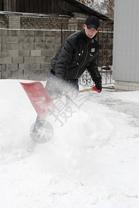 干净的冬天男子在暴雪中铲冷冻图片