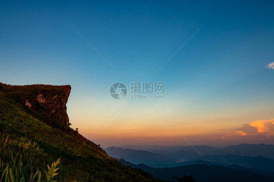 草假期美丽的山上高悬崖在日落时向天空倾斜图片