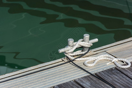 扭曲的血管卷绑在木制码头的一扇锁链上用绳子系住索图片
