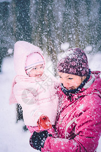 母亲在冬天和女儿一起户外活动与女儿一起过冬父母雪白天图片