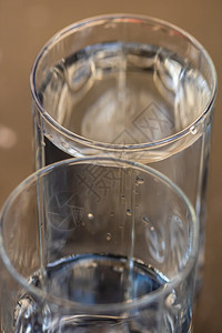 满杯的液体模糊背景下水玻璃的详细照片水倒入透明玻璃运动图片