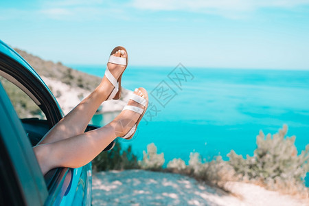 蓝车窗外的紧腿穿着蓝色车窗外的美丽自然背景靠近从汽车窗外的海面显示小女孩脚驾驶出去乐趣图片