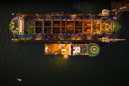 夜间在泰国照明灯光下对大型船只进行海上空中巡视和修理的大型船只力量厂重的图片