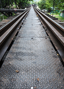行业火车亚洲人关闭旧铁路桥上的金属通道具有模糊的轮流背景泰国坎沙那毛里Kanchanaburi图片