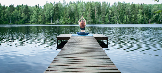 湖边做瑜伽的年轻女子图片