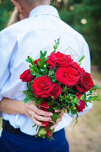新娘抱着一束美丽的红玫瑰花新娘抱着一束美丽的红玫瑰花开键承诺图片